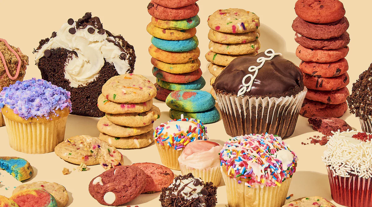 Assorted cupcakes and colorful stacked cookies displayed